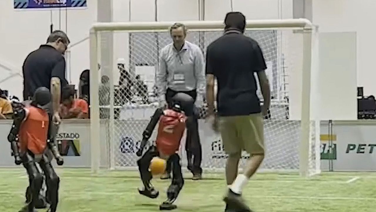 Humanoid robot scores goal against human goalkeeper during soccer match