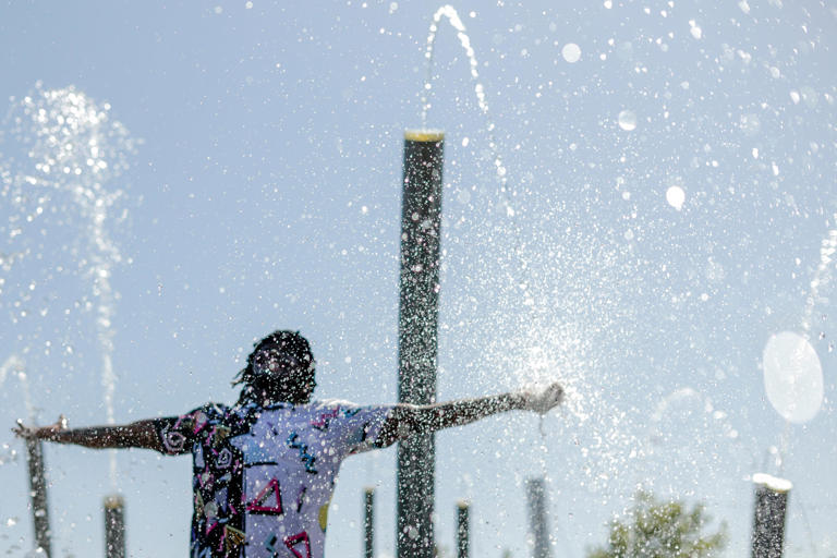 Trey Smith cools down in the splash pad at Scissortail Park during a heat wave in Oklahoma City on Thursday, Aug. 20, 2026.