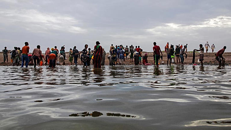 Ethiopian migrants walk on the shores of Ras al-Ara, Lahj, Yemen, after disembarking from a boat, July 26, 2019.