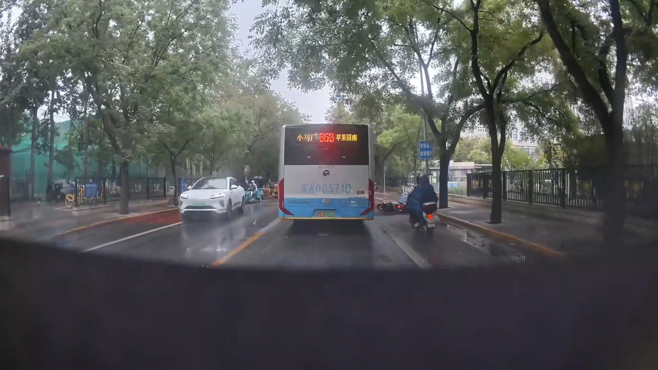 Motorcycles slide and fall on wet road in Beijing