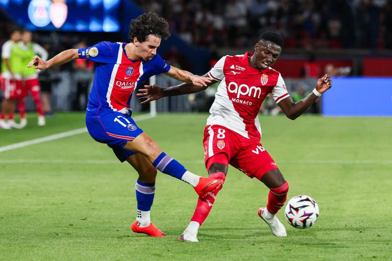 Vitinha of PSG is challenged by Lamine Camara of AS Monaco.