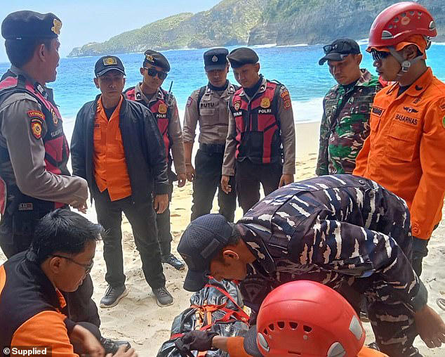 Emergency crews attend the scene on the beach after the fatal fall