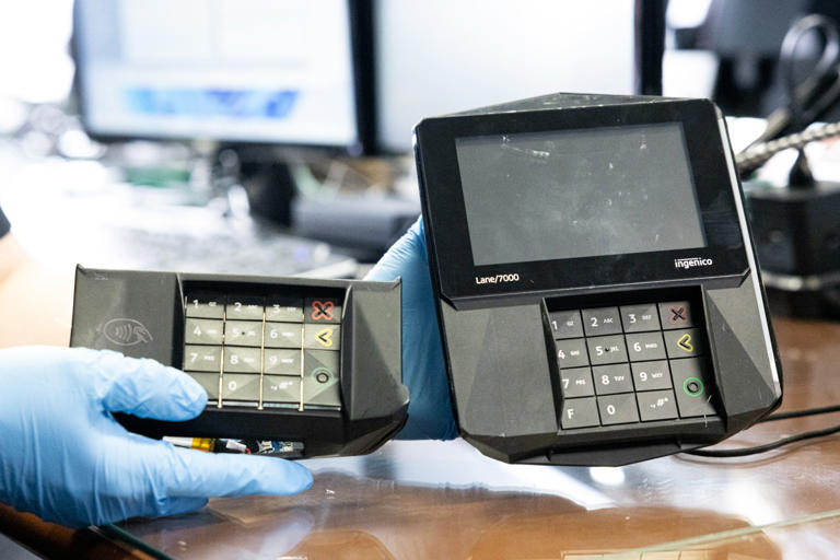 A Secret Service investigator holds an illegal card skimmer detached from a credit-card reader.
