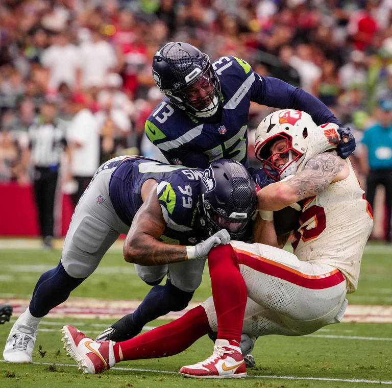 Seattle Seahawks Leonard Williams (99) and Ernest Jones (13) tackle Cardinals tight end Trey McBride (85) during a game at State Farm Stadium in Glendale, Ariz. on Sept. 20, 2026.