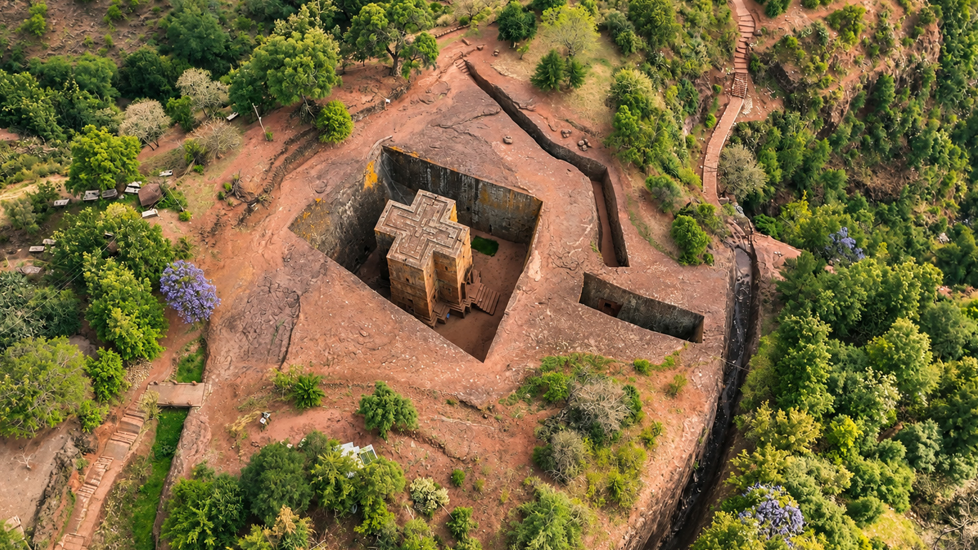 A cross-shaped church standing below ground level
