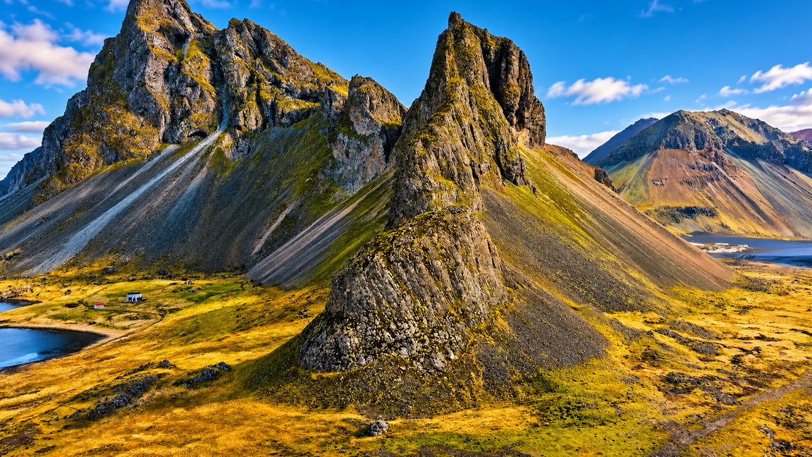 Iceland’s dramatic mountain peaks rise above a golden valley