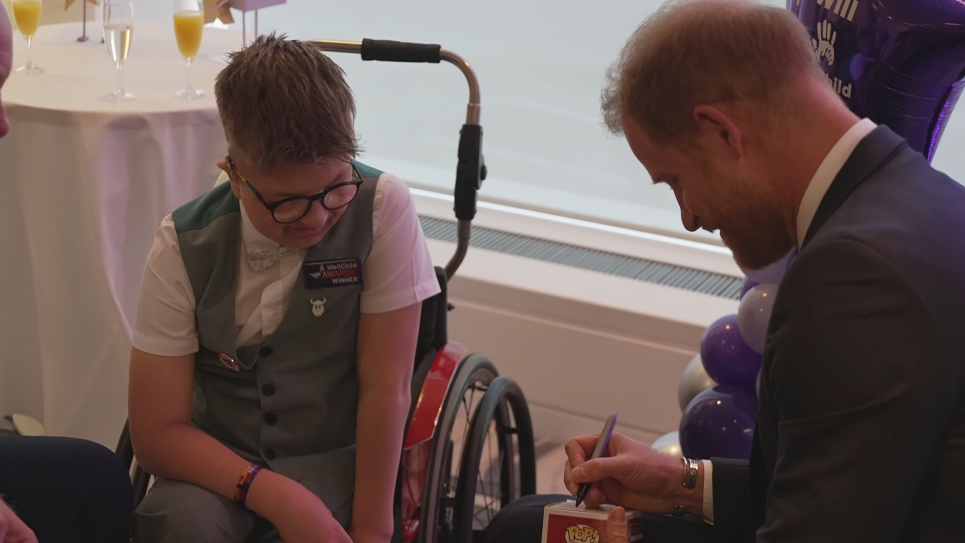 Prince Harry signs his mini figure