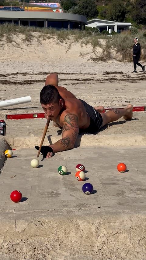 Brothers build a billiards table in the sand at the beach