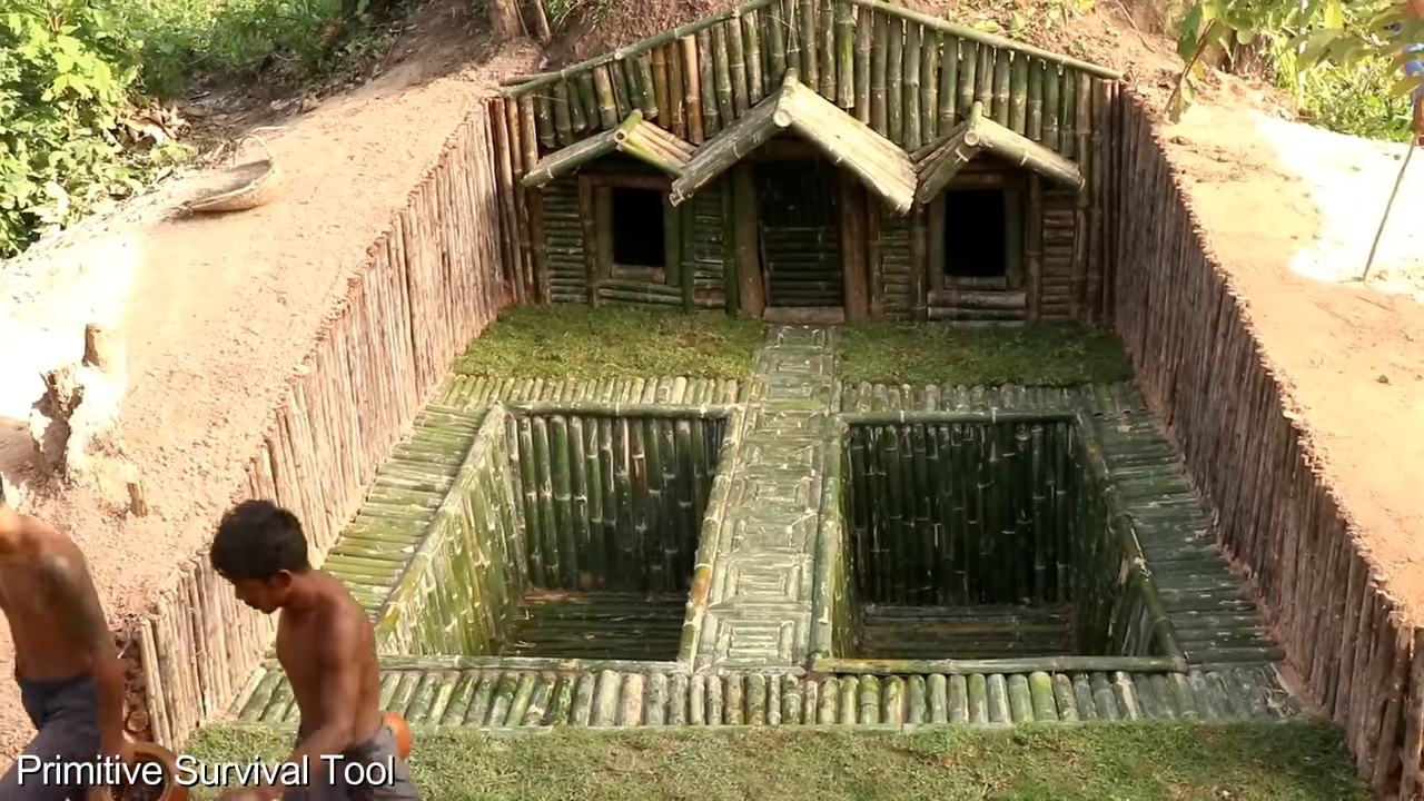 Two men build a hidden underground shelter under tree roots with two pools