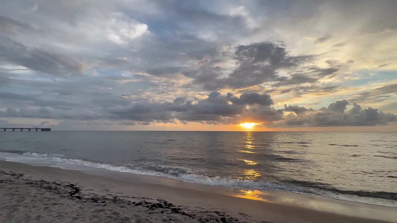 Golden sunrise breaks through dramatic clouds over Atlantic Ocean in ...