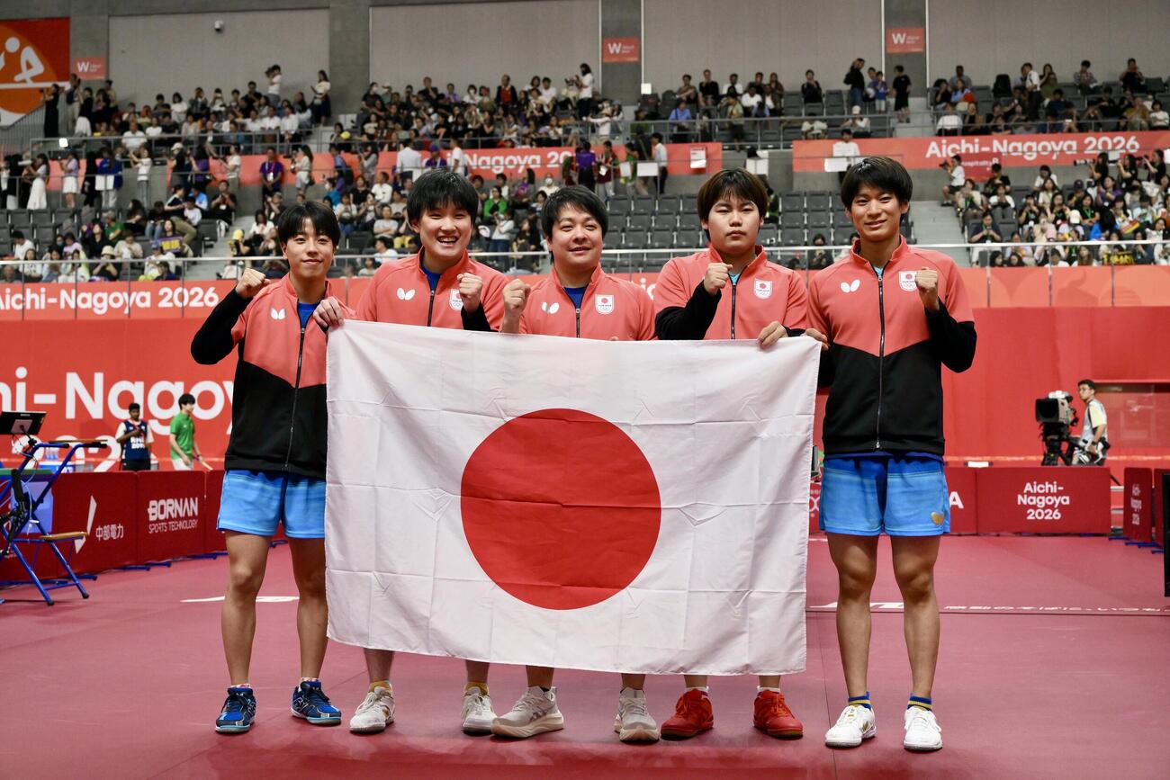 【写真】男子団体決勝 中国を破り優勝を決め日の丸を手に記念撮影する選手たち（撮影・滝沢徹郎）