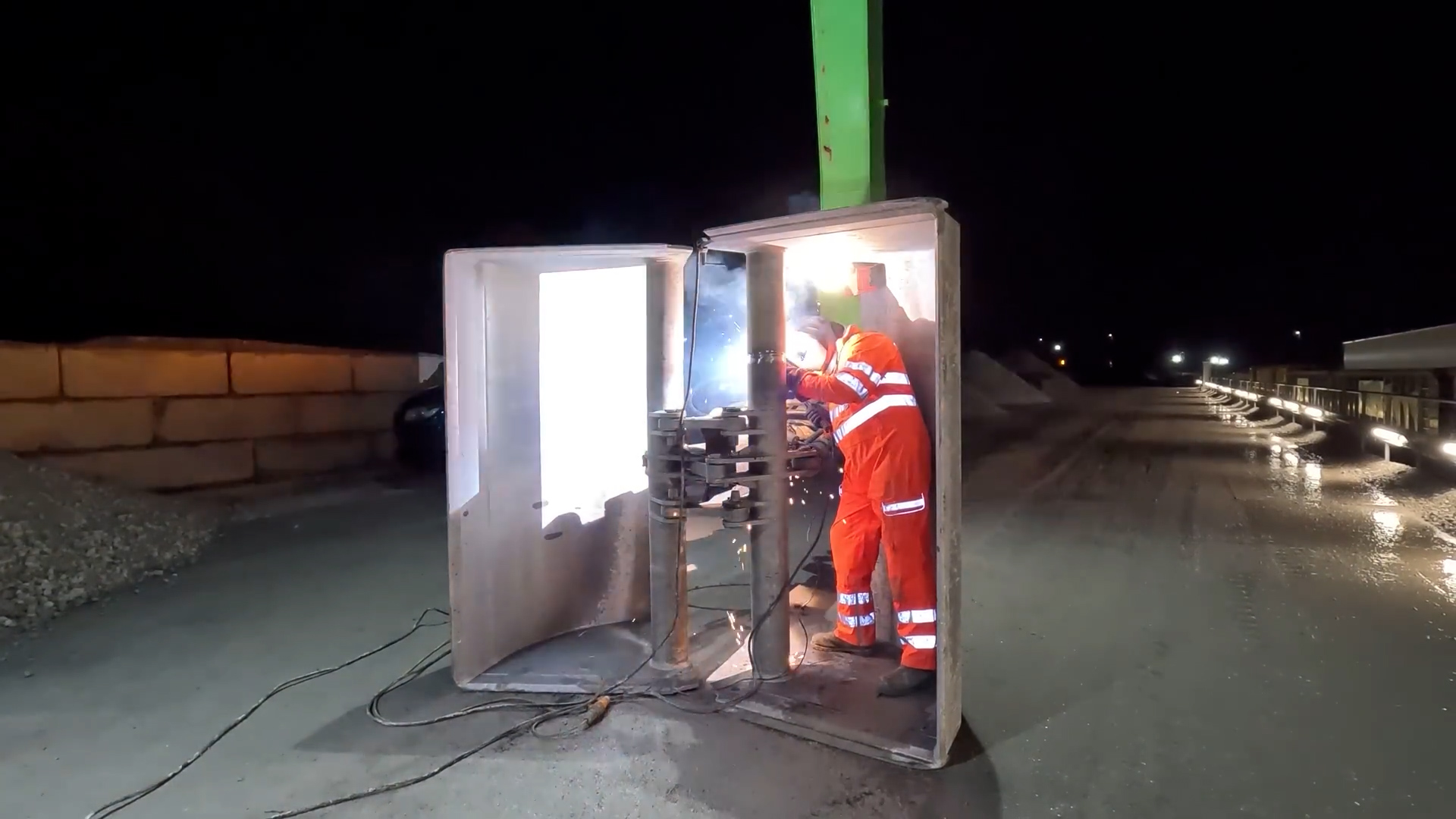 Night shift welding under pressure on heavy industrial equipment