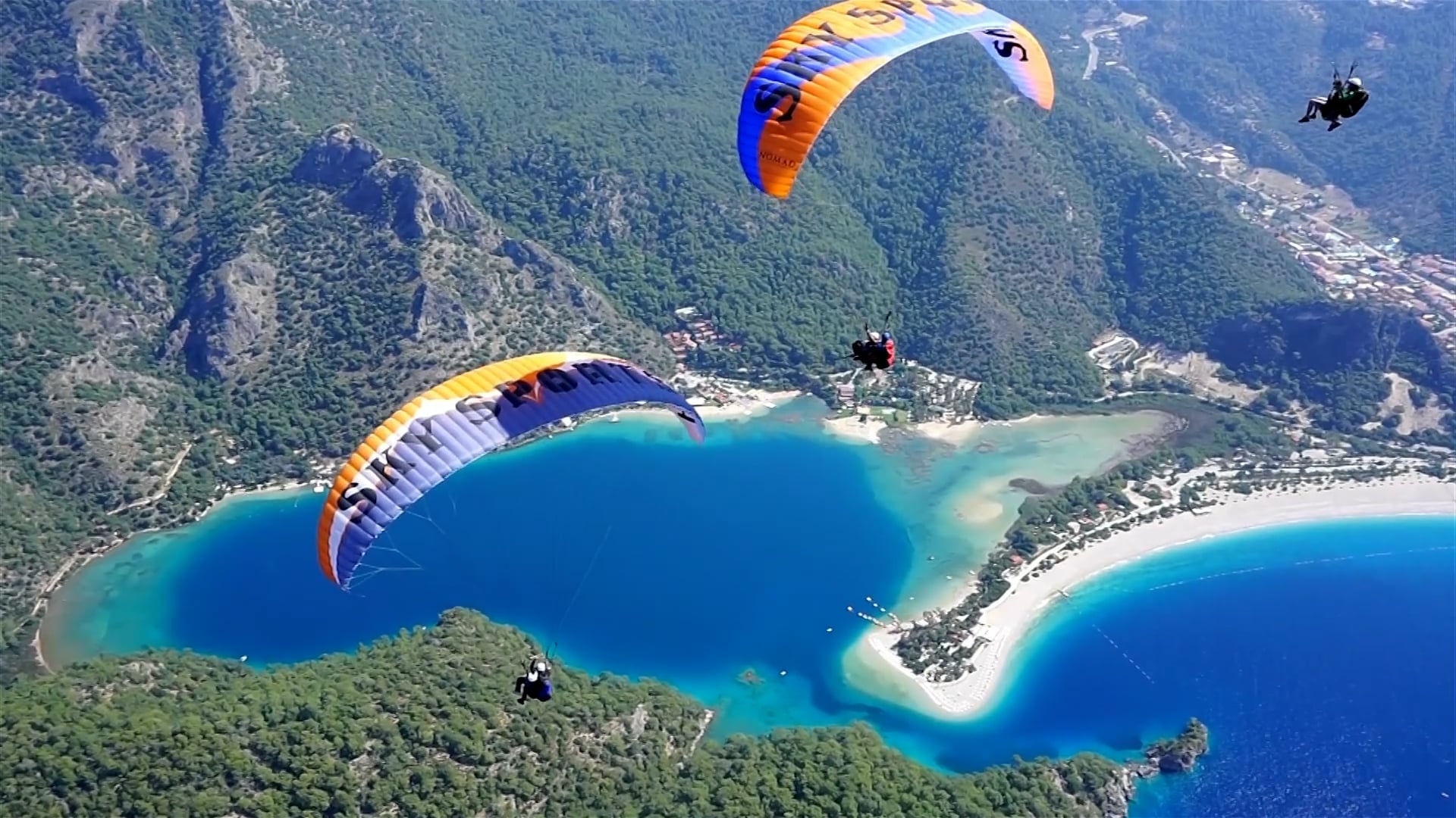 Paragliders soar over stunning landscapes in aerial drone footage