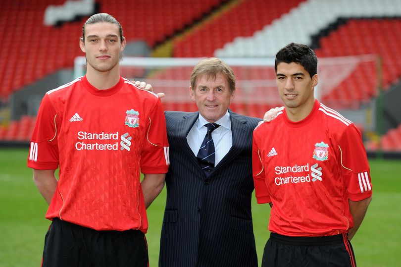 New signings Andy Carroll (L) and Luis Suarez (R) of Liverpool pose for a photograph with manager Kenny Dalglish on the pitch at Anfield on February 3, 2011 in Liverpool, England.