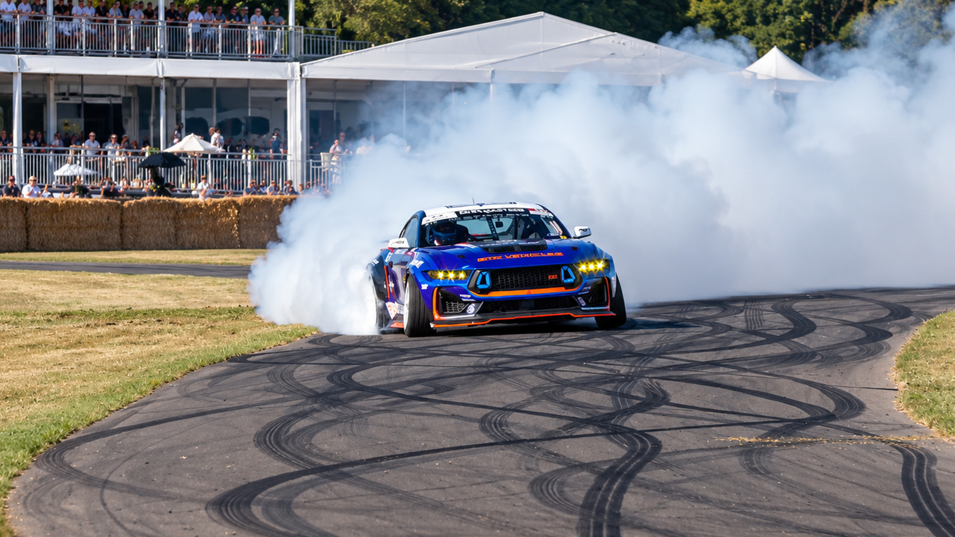 Ford Mustang RTR drifts aggressively through a smoke-filled track