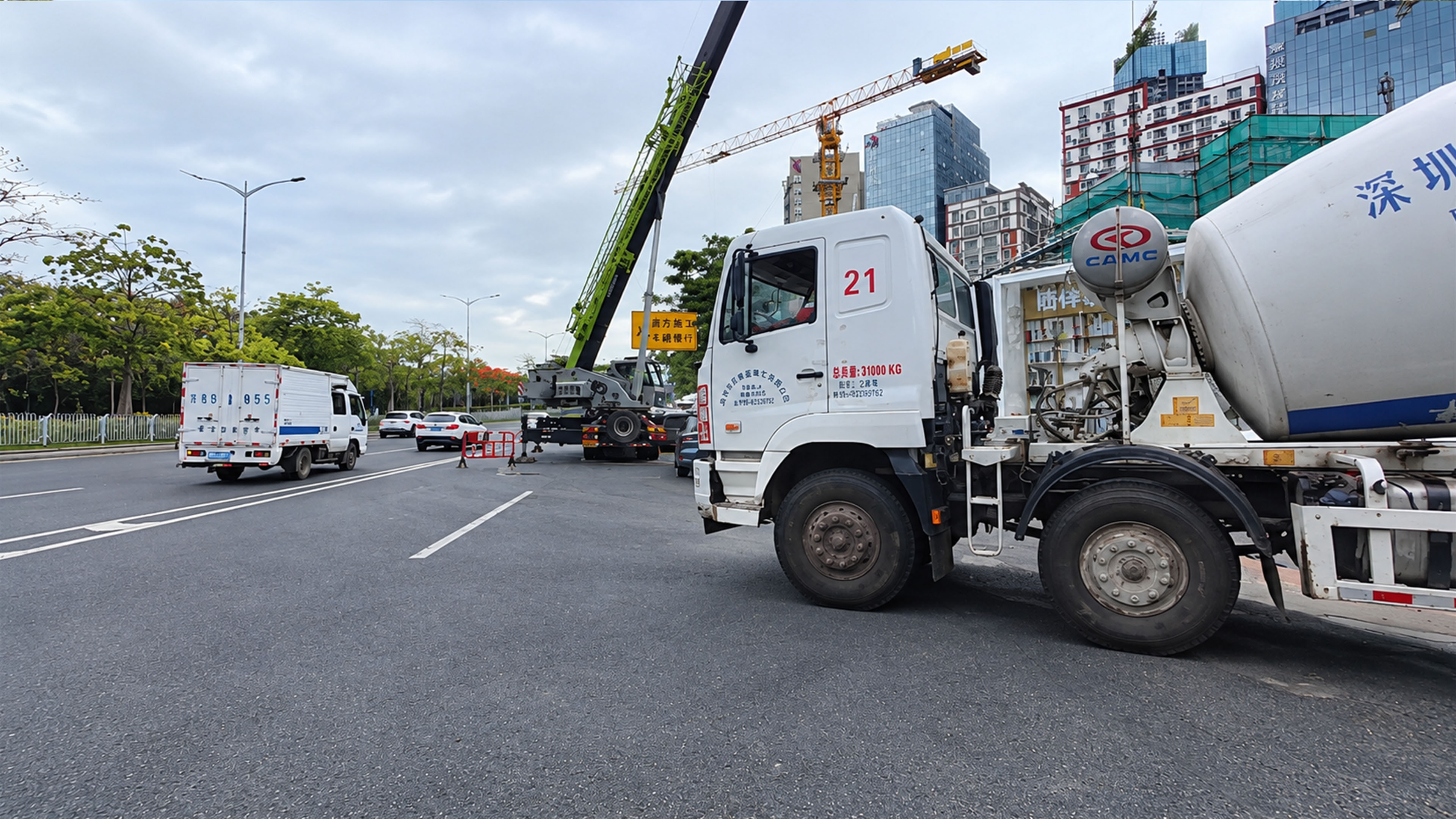Grues et véhicules de chantier partagent la route avec la circulation à ...