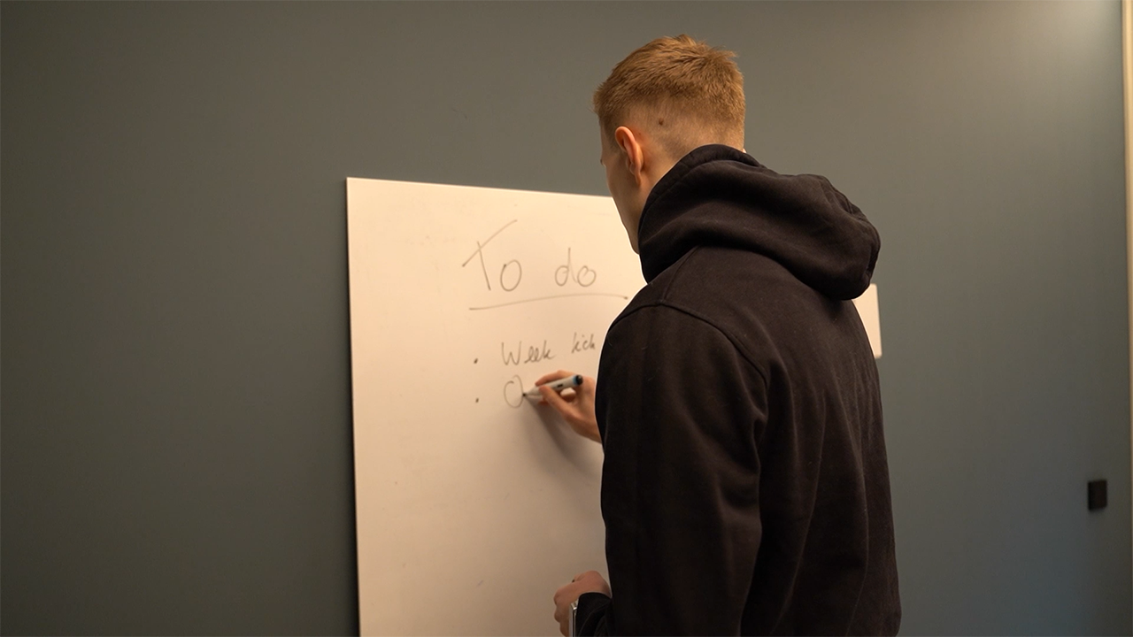Writing a to do list on a whiteboard to organize daily tasks