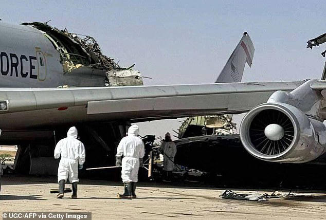 Personnel in protective suits inspect a heavily damaged aircraft, its radar section ripped apart in what appears to be a targeted strike on critical systems last March