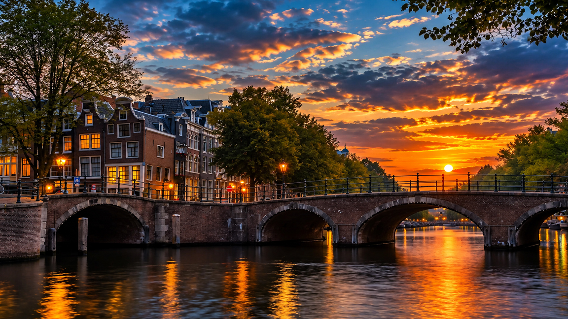Amsterdam’s historic canals glow beneath a golden sunset