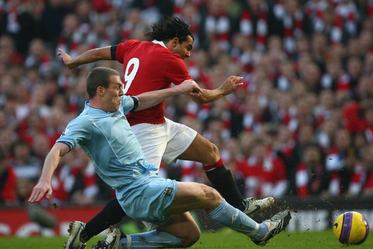 Carlos Tevez is tackled by Richard Dunne
