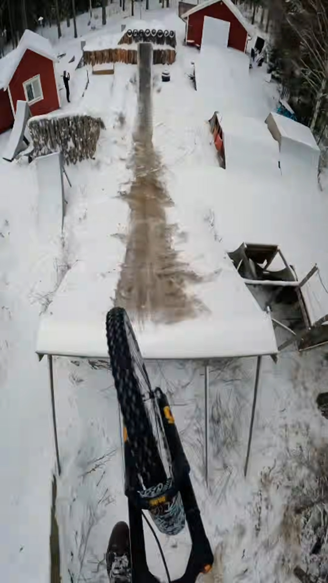 Extreme mountain biking down snow covered wooden ramps