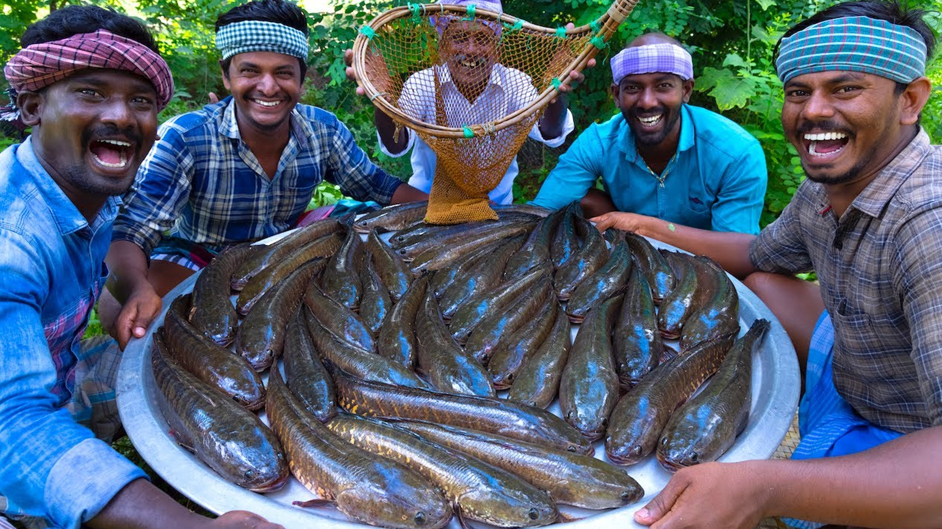 Village chefs prepare a river fish fry using traditional cooking methods