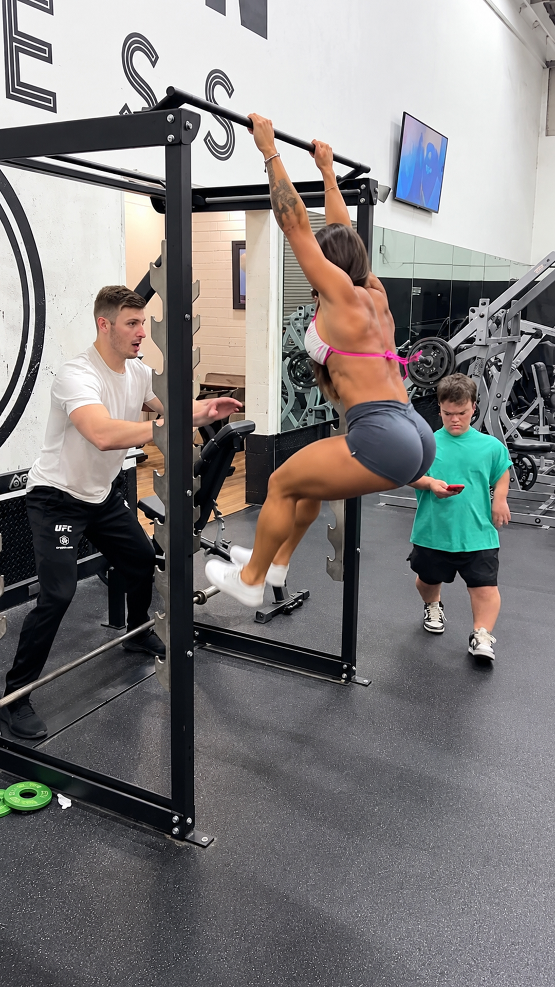 Watch a gym accident happen when a distracted man walks behind the rack