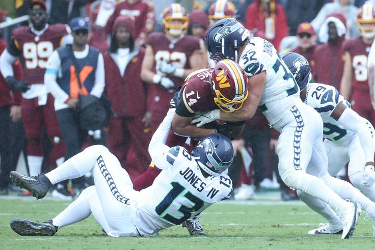 Seattle Seahawks LB Drake Thomas and LB Ernest Jones IV tackle Washington Commanders wide receiver Antonio Williams. | IMAGN IMAGES via Reuters Connect