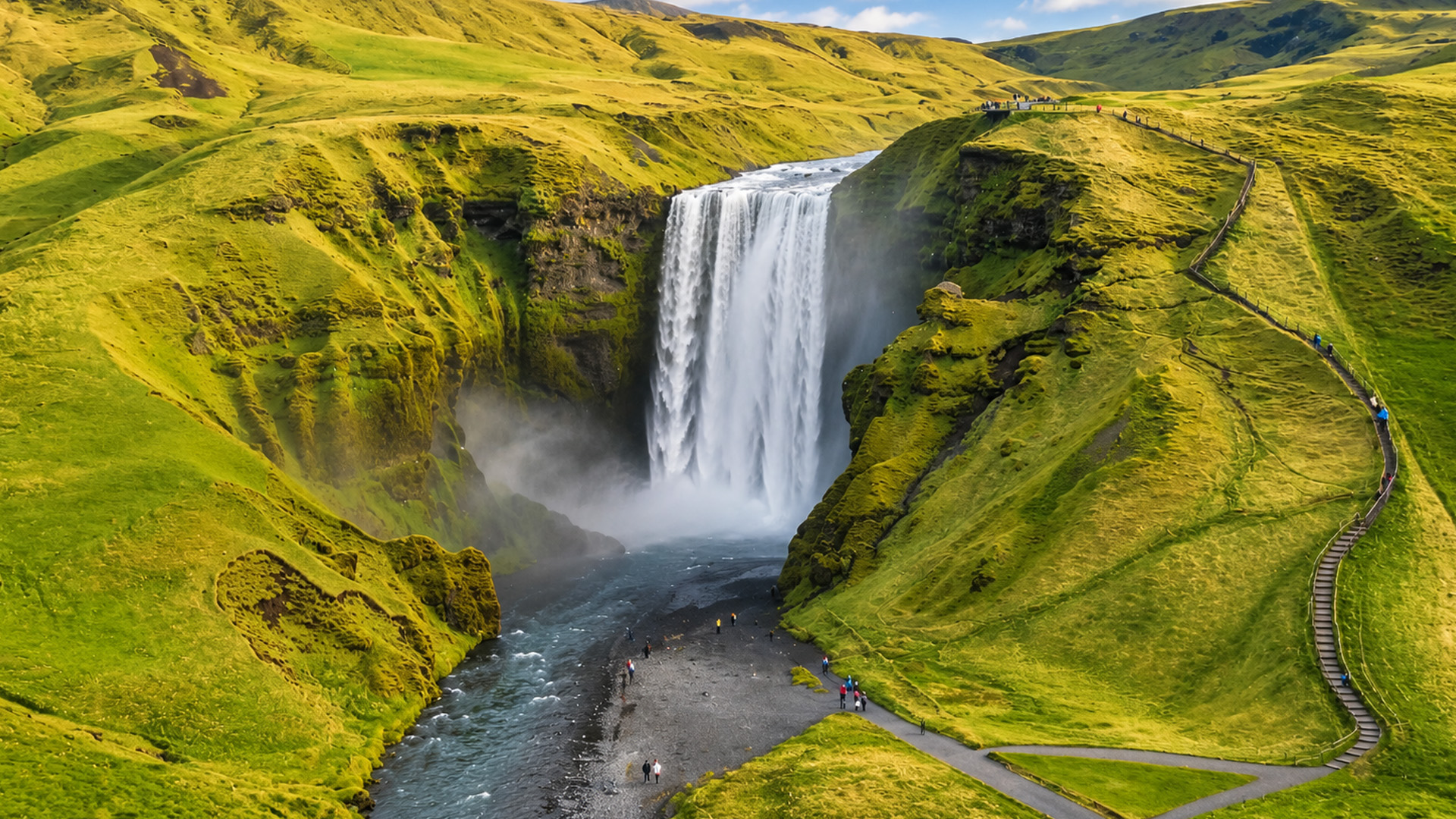 Visitors walking below one of Iceland’s famous waterfalls