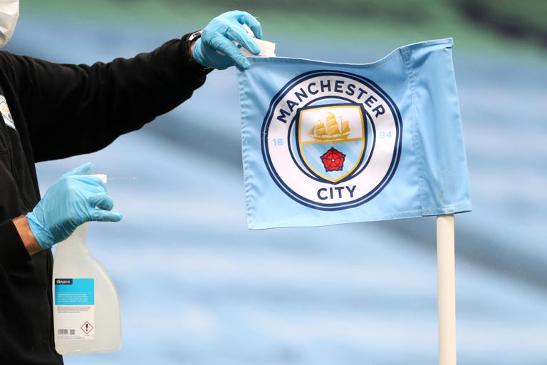 FILE - A groundsman disinfects a corner flag ahead of the English Premier League soccer match between Manchester City and Burnley at Etihad Stadium, in Manchester, England, Monday, June 22, 2020. (AP Photo/Martin Rickett,Pool, File)