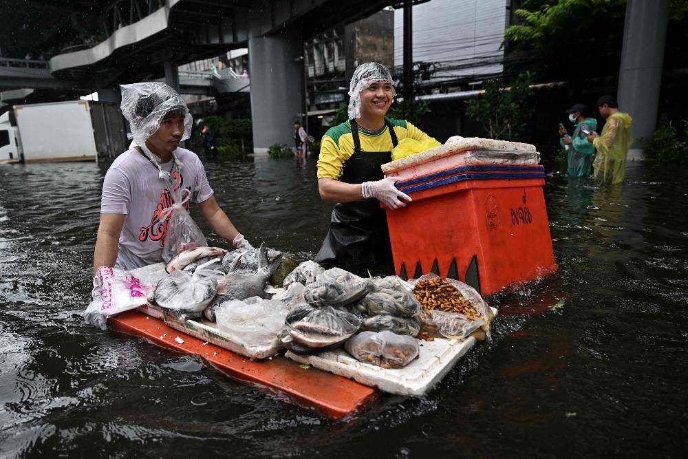 In kayaks or waist-deep in floodwater, shoppers return to Bangkok markets