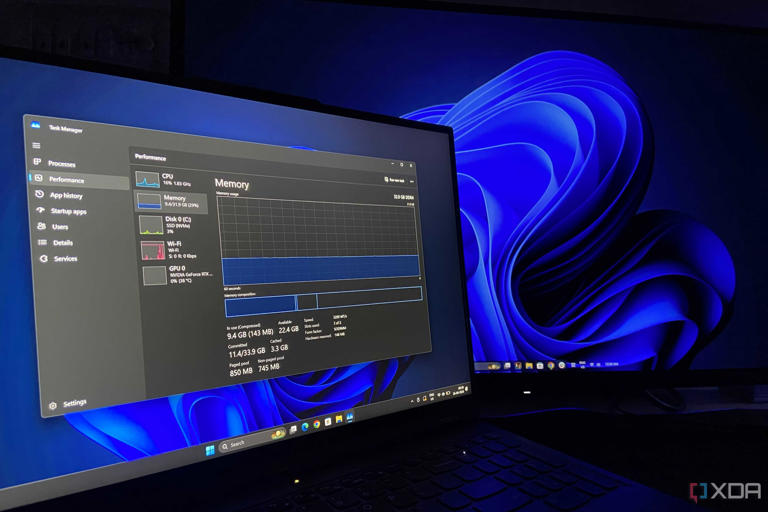 A laptop running task manager next to a desktop PC.
