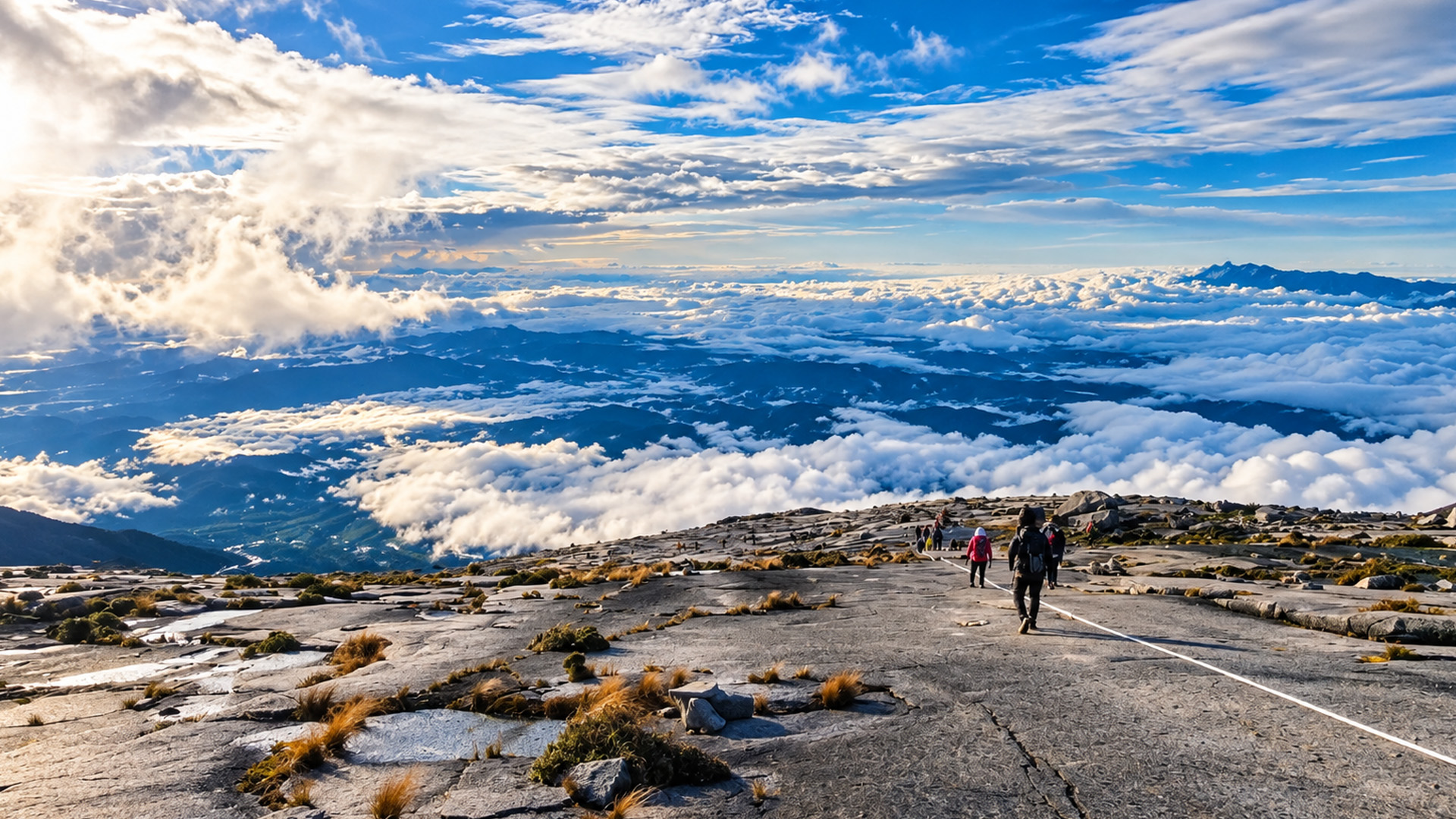 Senderistas cruzan la roca desnuda cerca de la cima del monte Kinabalu