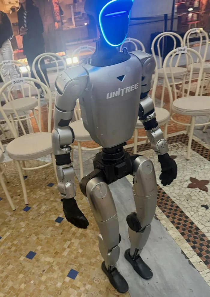 Fans react after seeing robots walking down the runway during Milan ...