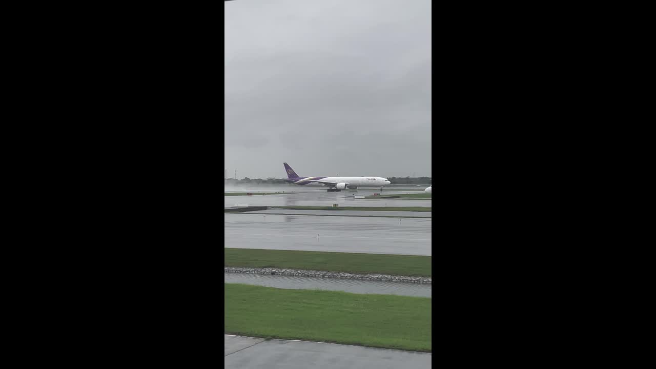 Thai Airways Boeing 777 takes off on flooded runway as rain lashes Bangkok