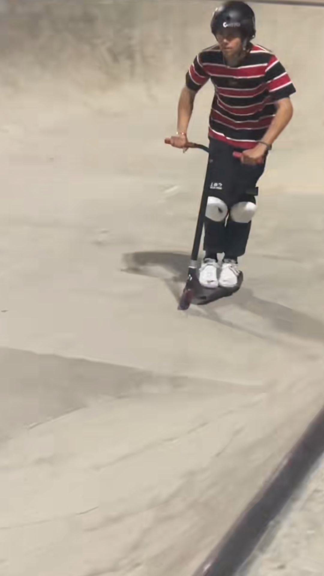 Scooter rider nails a clean landing at the skatepark