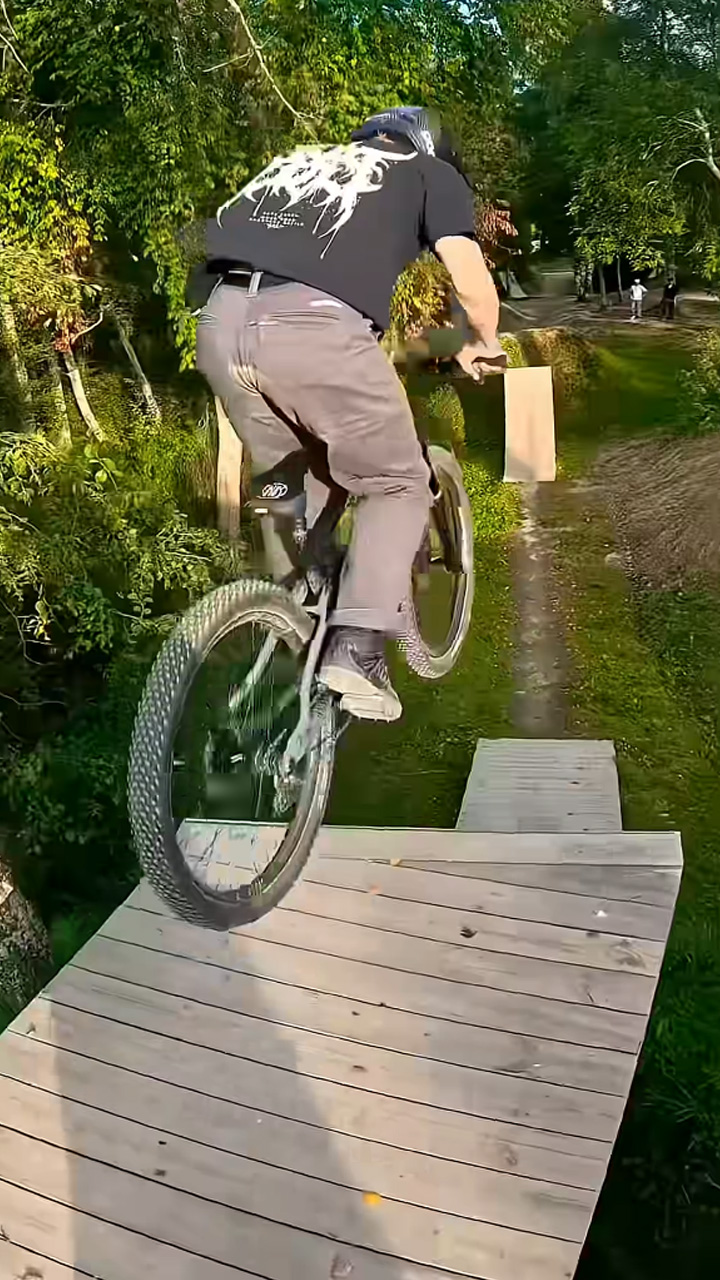 Hitting massive wooden jumps on a downhill mountain bike