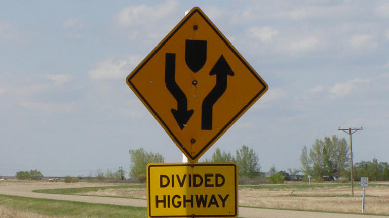 What does a road sign with two arrows pointing downward mean?