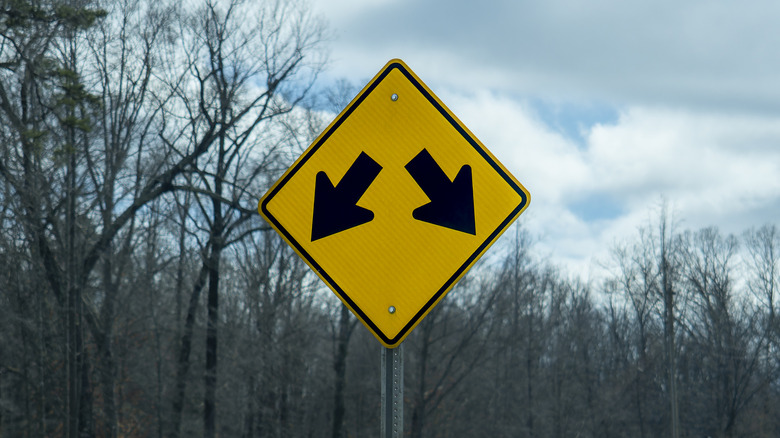 What does a road sign with two arrows pointing downward mean?