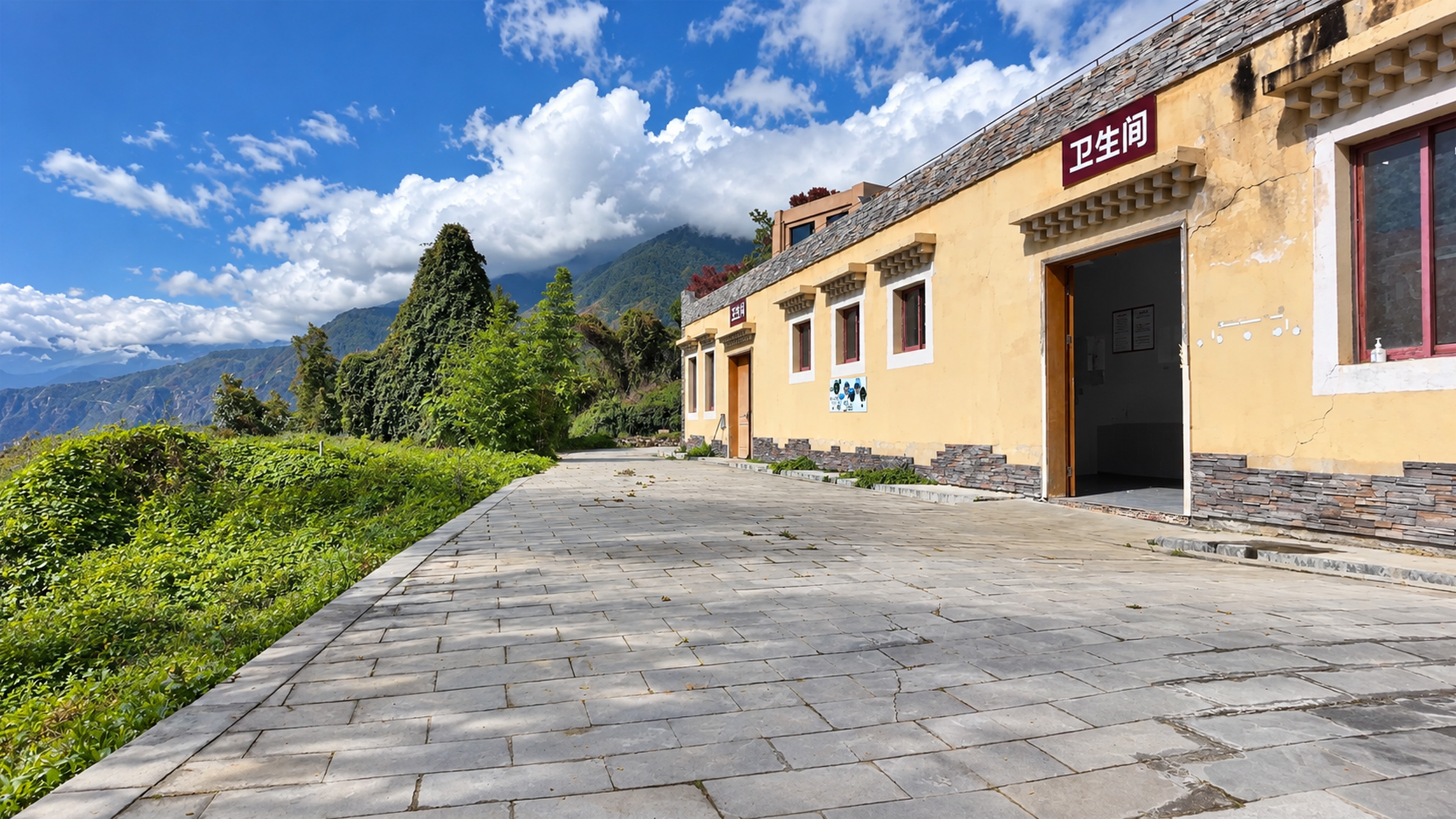 A public restroom faces towering mountains in rural China