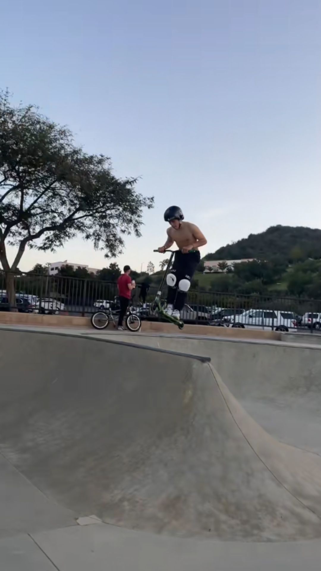 Freestyle scooter riding in the skatepark bowl