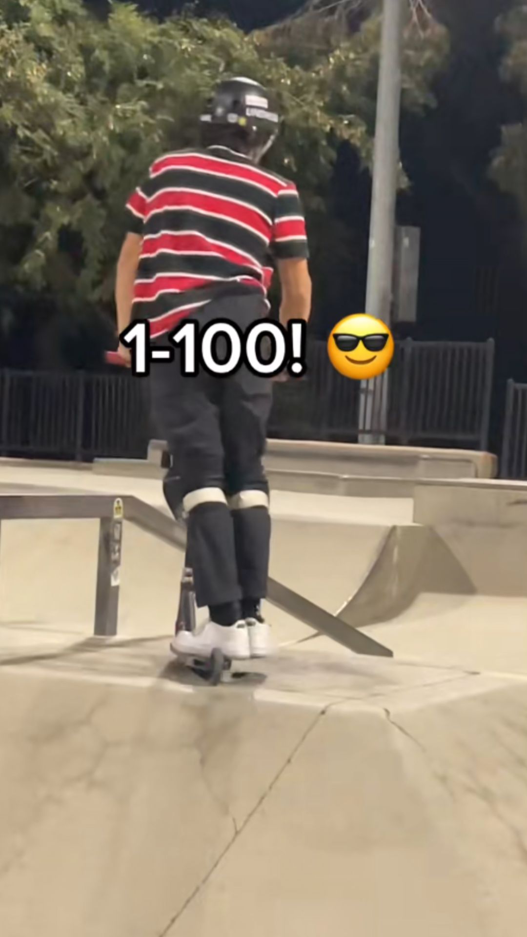 Freestyle scooter trick over the rail at a night skatepark session