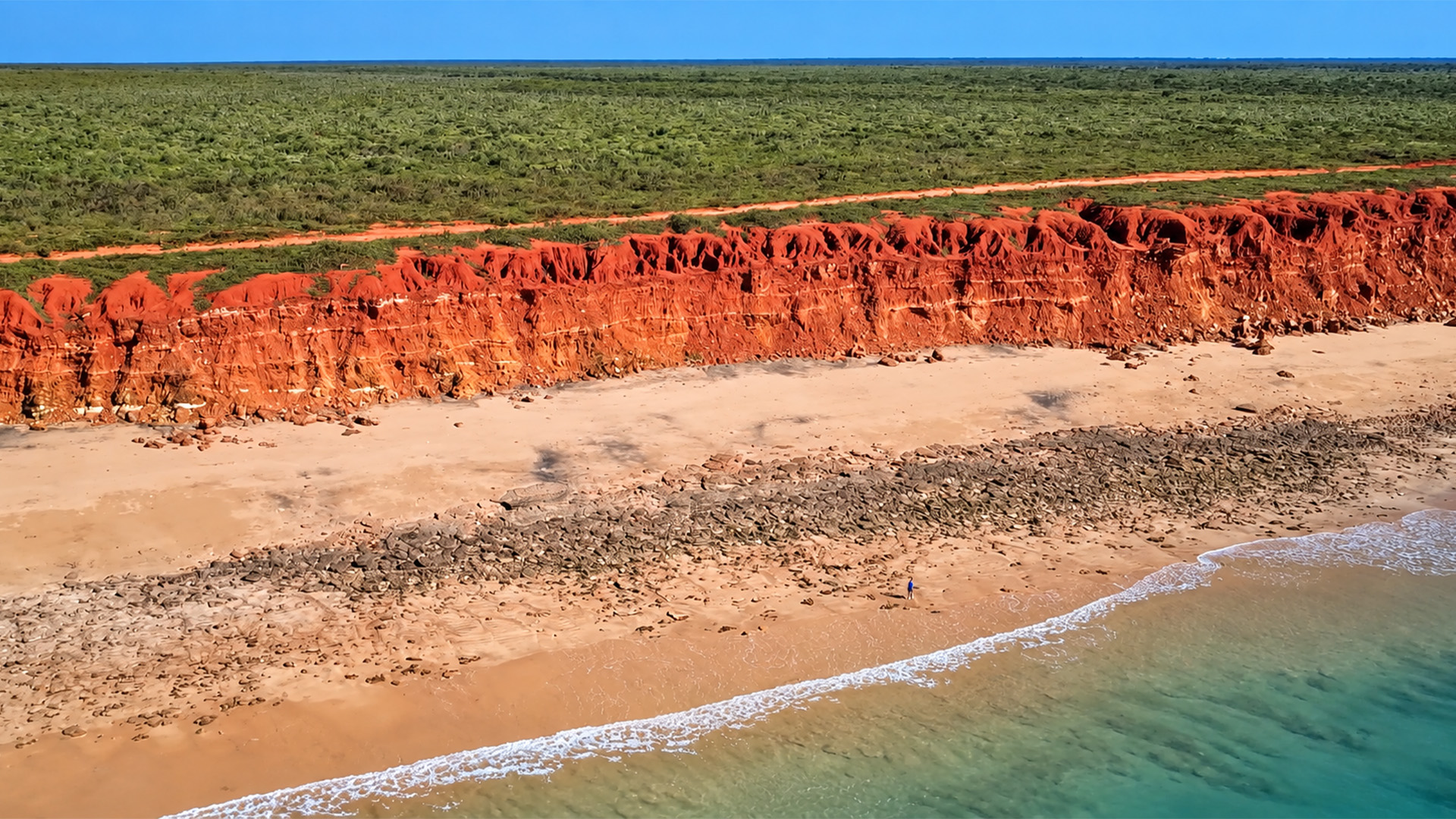 Road tripping past red cliffs in Western Australia