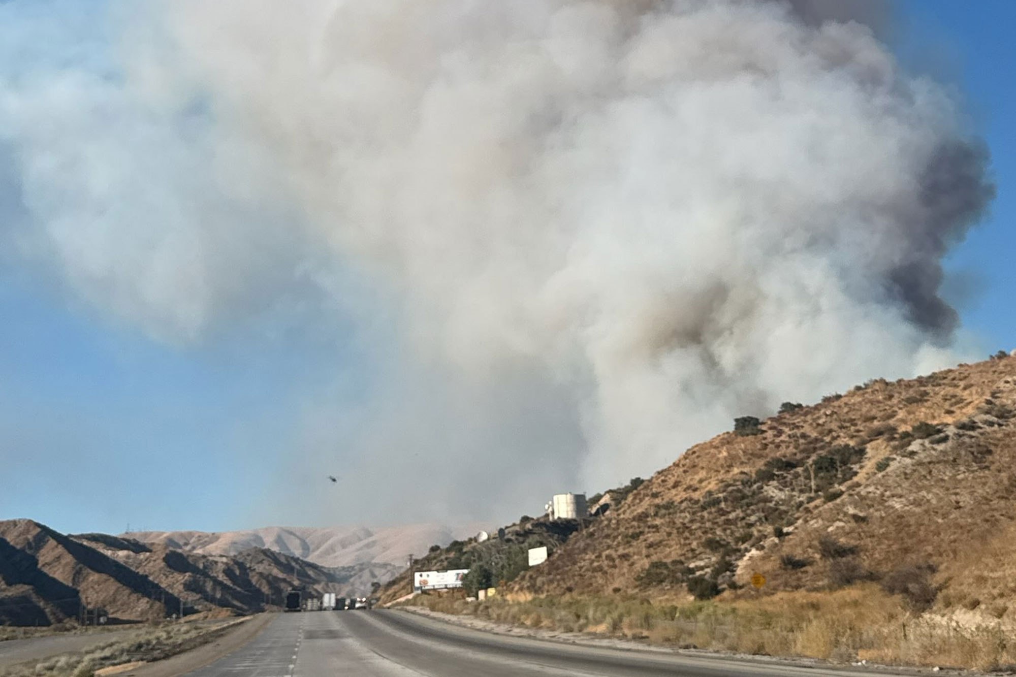 Fast-moving wildfire shuts down major California freeway as flames rage
