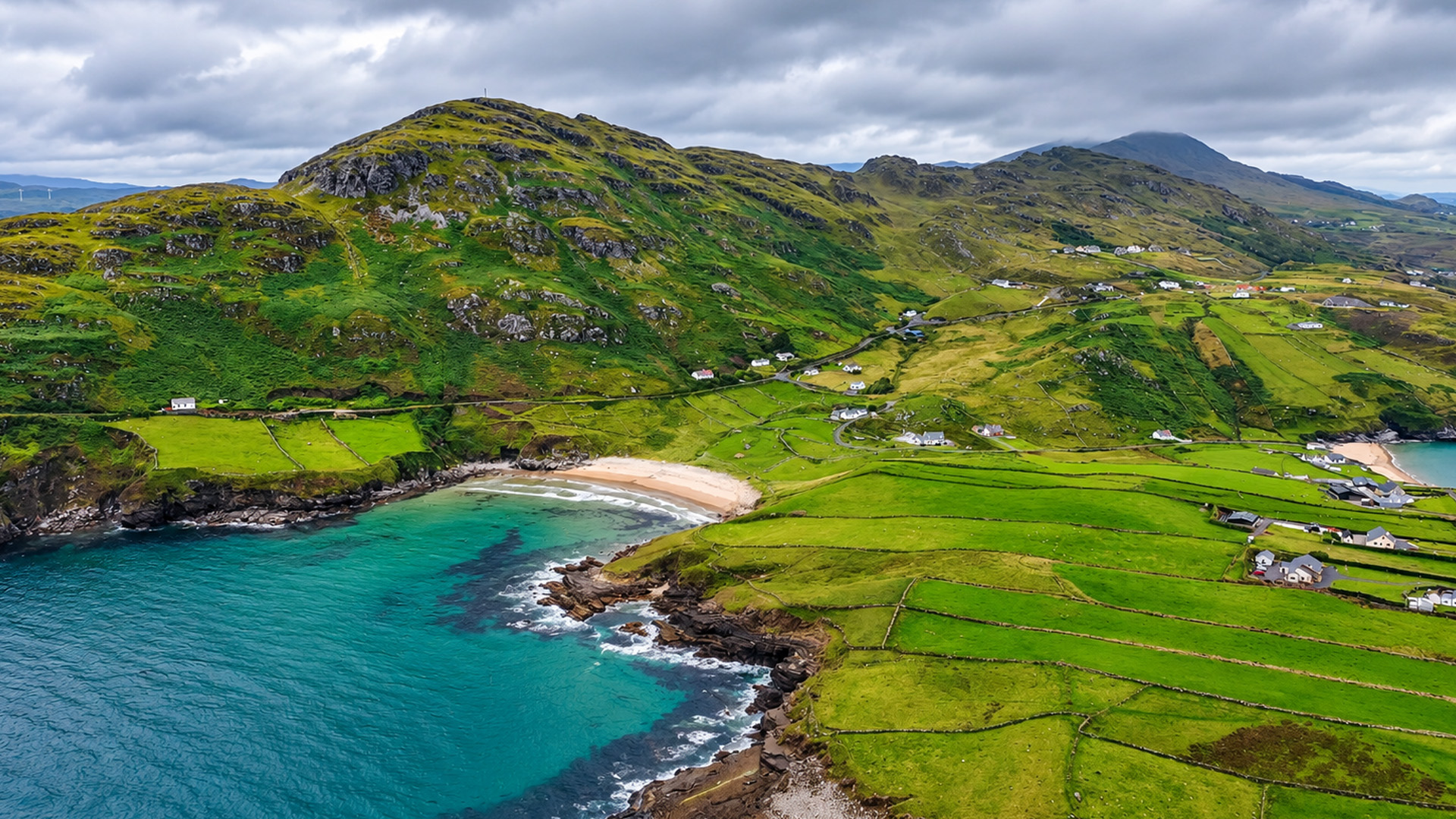 Small farms cover the hills beside the Atlantic