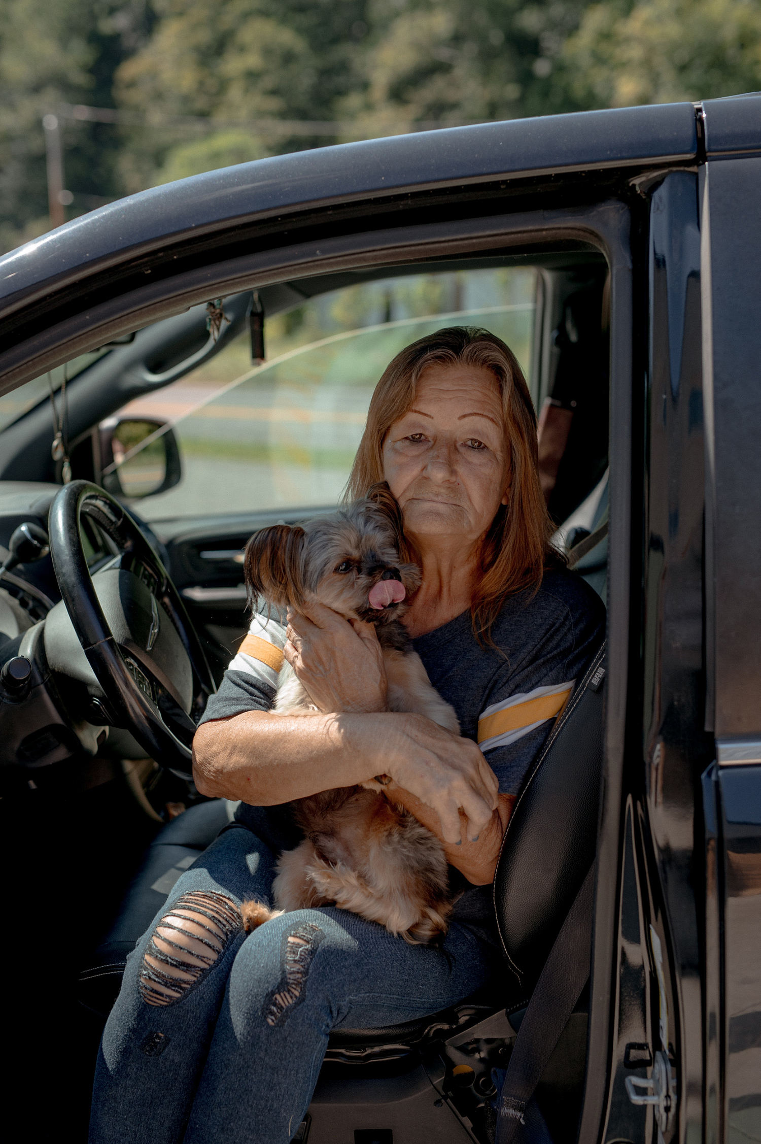 Joanne Girvin and her dog, Jasper, sat in line for several hours for a few boxes of food. Rising gas prices have cut into her grocery budget. (Mike Belleme for NBC News)