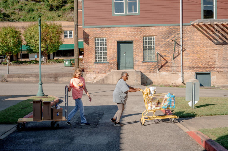 Donna Paterino helps Mary Blackwell take food for her and her son's family to her vehicle at the Widow's Mite Food Pantry. (Mike Belleme for NBC News)