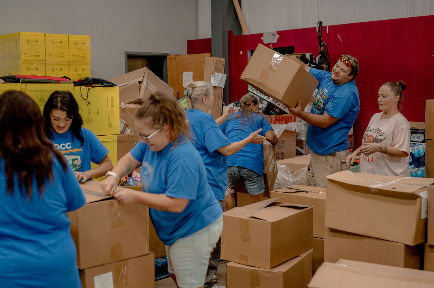 Volunteers and staff members sort through a maze of boxes of donated goods inside the Dunlow Community Center. (Mike Belleme for NBC News)