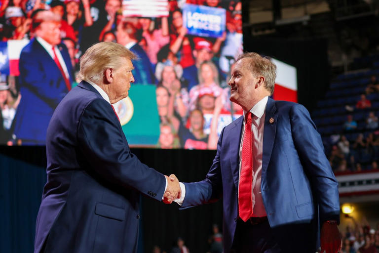 Donald Trump (L) shakes hands with Ken Paxton on stage during a campaign rally, Freeman Coliseum, San Antonio, October 7, 2026.