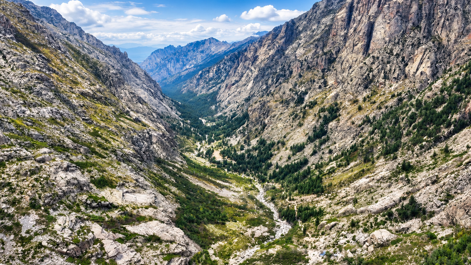 Giant granite cliffs rising above a narrow green valley